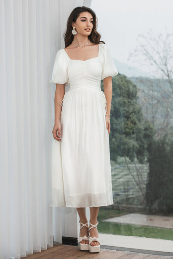 En linje plisseret lille hvid kjole med pufærmer